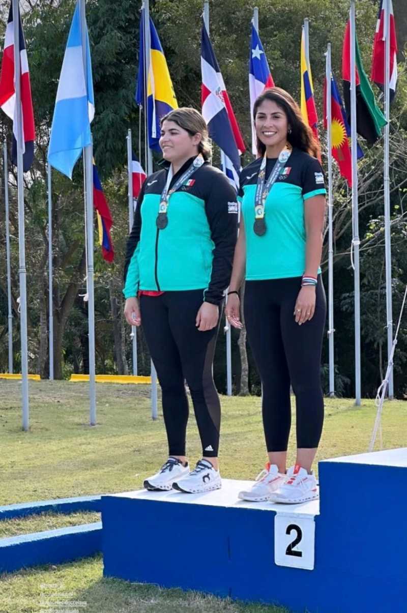 Mexican women's shooting team holding silver medals, smiling and wearing team uniforms.