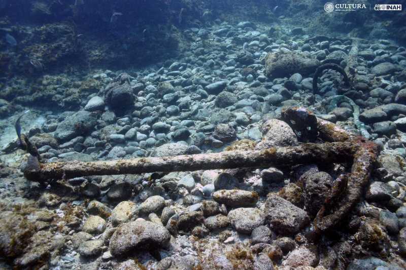 A diver swims past a shipwreck on the coral reef of Banco Chinchorro, Mexico.