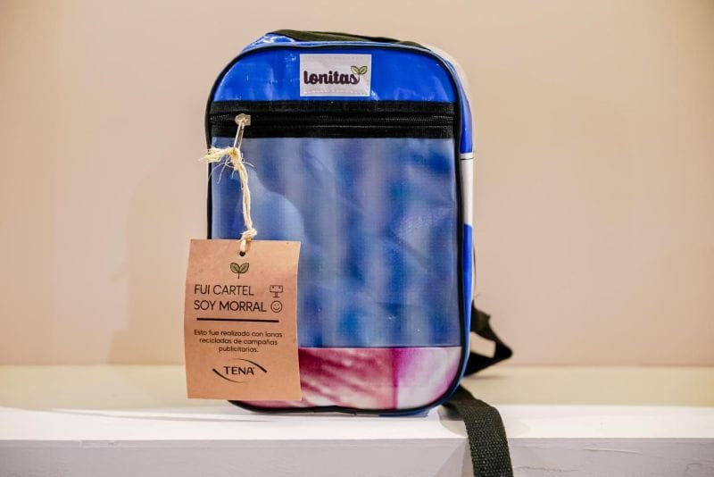 A blue and pink backpack created from repurposed vinyl ad banner material.