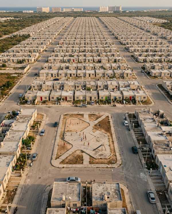 Aerial view of Villas Otoch Paraíso, a working-class housing development in Cancún with rows of identical small concrete homes.