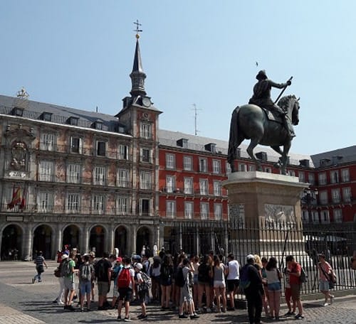 Tourists gather at the foot of the statue of Philip V.