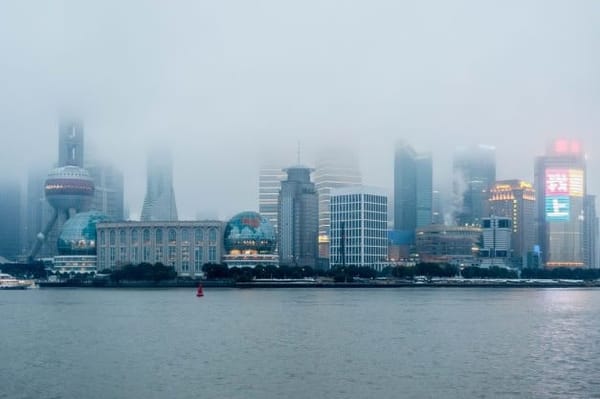 Chinese city on a foggy day with some bright billboards.