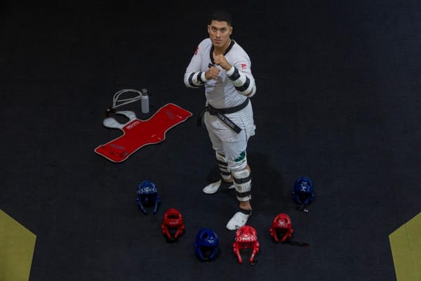 Carlos Sansores, a taekwondo athlete, standing tall with a contemplative expression.