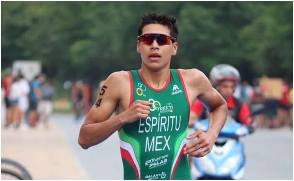 A male triathlete in sportswear stands confidently, ready for competition.