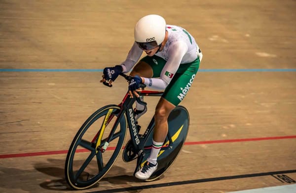 Mexican cyclist in a team pursuit race, his body crouched low over their bike in the velodrome.