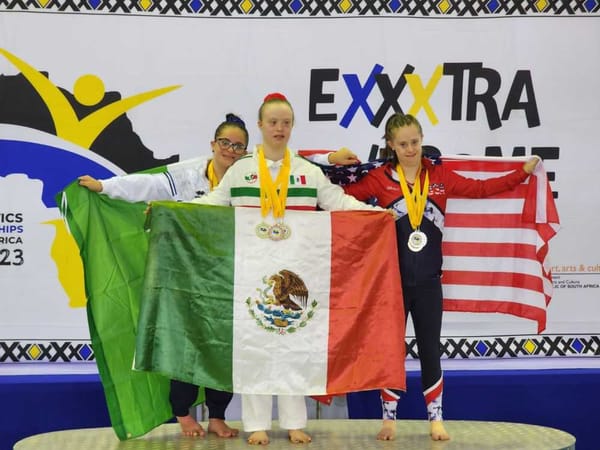 The Mexican Trisomy Games delegation poses for a team photo, beaming with pride while holding the Mexican flag.