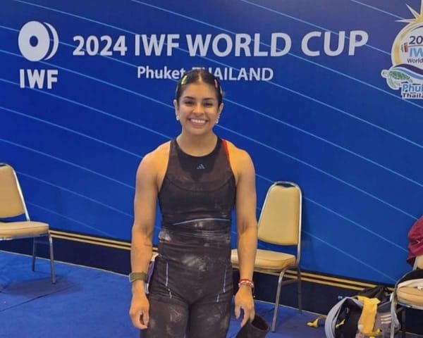 Ana Gabriela López Ferrer, a determined weightlifter, lifts weights during the competition.