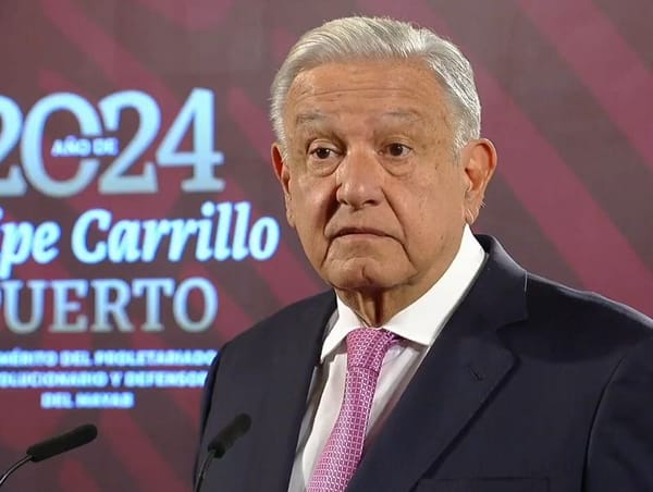 Mexican President standing at a podium, speaking into a microphone.