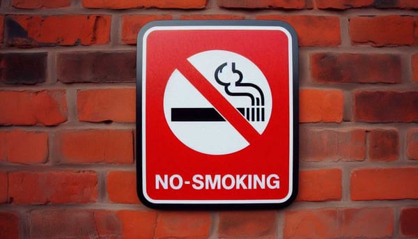 No-smoking sign on a red brick wall.