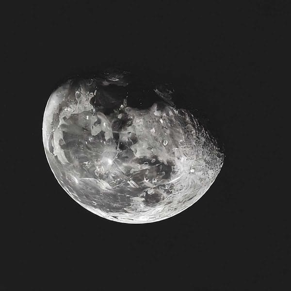 A close-up of the Moon, with craters and mountains visible on its surface.