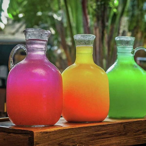 A colorful array of Mexican fresh waters in traditional glass jars.