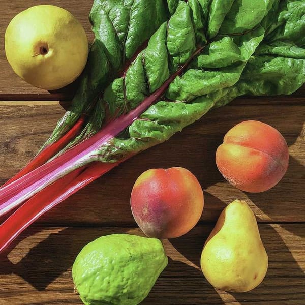 A colorful array of Mexican fruits and vegetables, including guava, pear, peach, and chard.