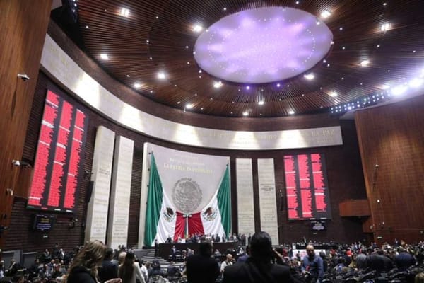 A group of Mexican politicians gathered in a chamber, debating and voting on new welfare legislation.