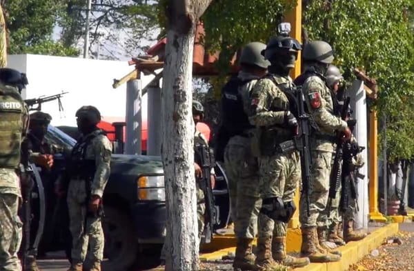 A convoy of military vehicles carrying armed soldiers enters Culiacán.