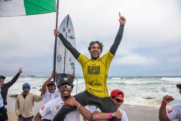 Sebastián Williams standing on the podium, holding his gold medal at the Pan American Surfing Games.