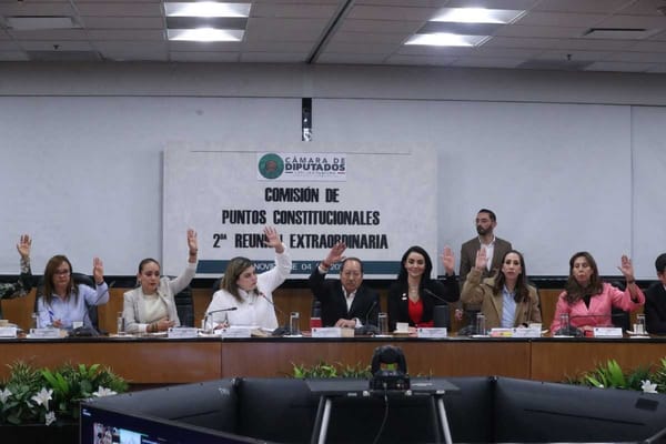 A group of people, likely lawmakers, gathered around a table, discussing a document.