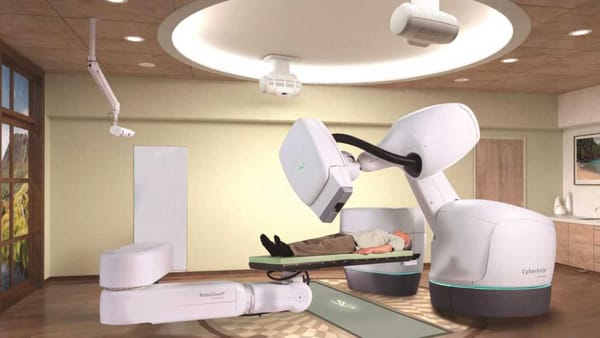 A robotic arm of the CyberKnife system hovers over a patient inside the modern radiotherapy suite.
