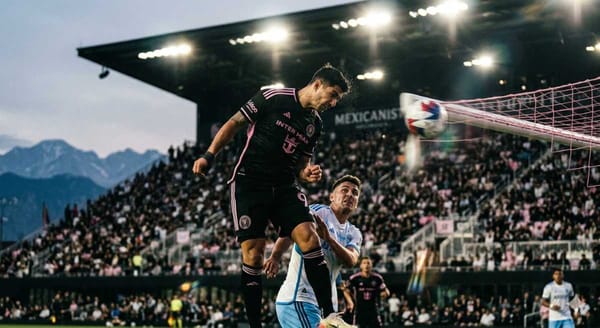 A Mexican football striker rises above a defender to score a header for Inter Miami.